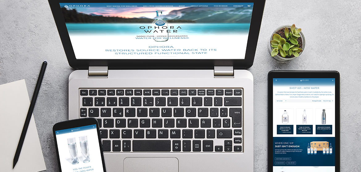 A laptop, phone, and tablet arranged neatly on a desk, showcasing website design for Ophora Water.