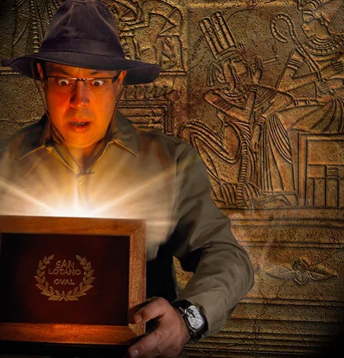 A man in a hat holds a glowing box, reminiscent of Indiana Jones exploring an Egyptian tomb for hidden treasures