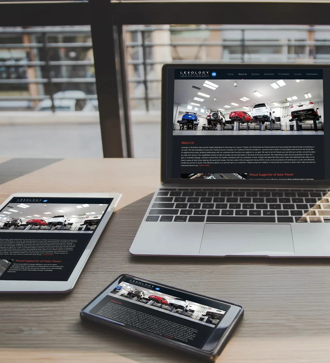 A laptop, tablet, and phone arranged neatly on a desk, showcasing modern tech for Lexology Auto Shop's website design